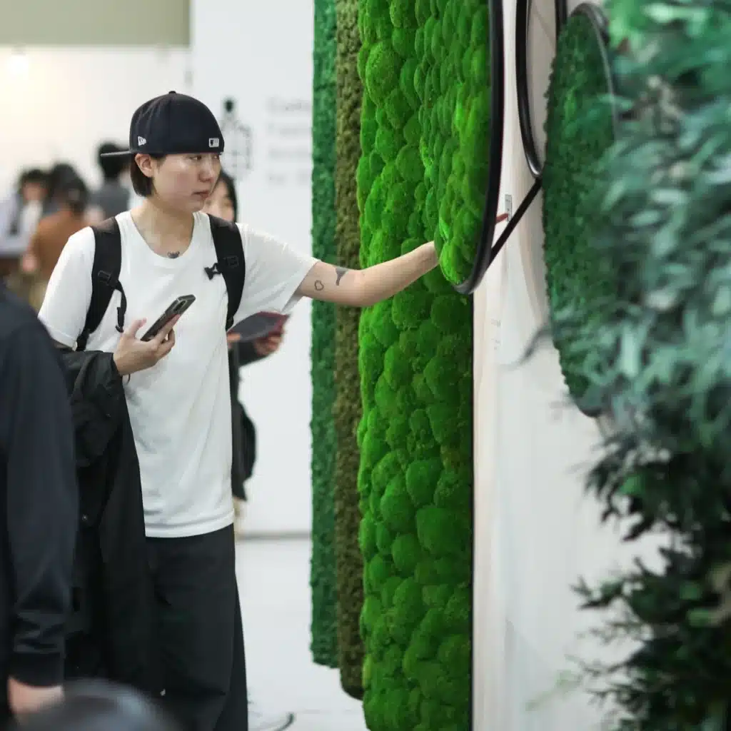 Person examines green vertical garden display