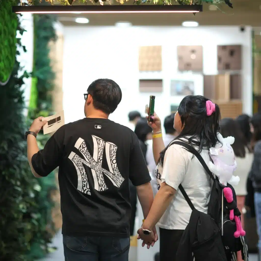 Couple holding hands, exploring art exhibition.