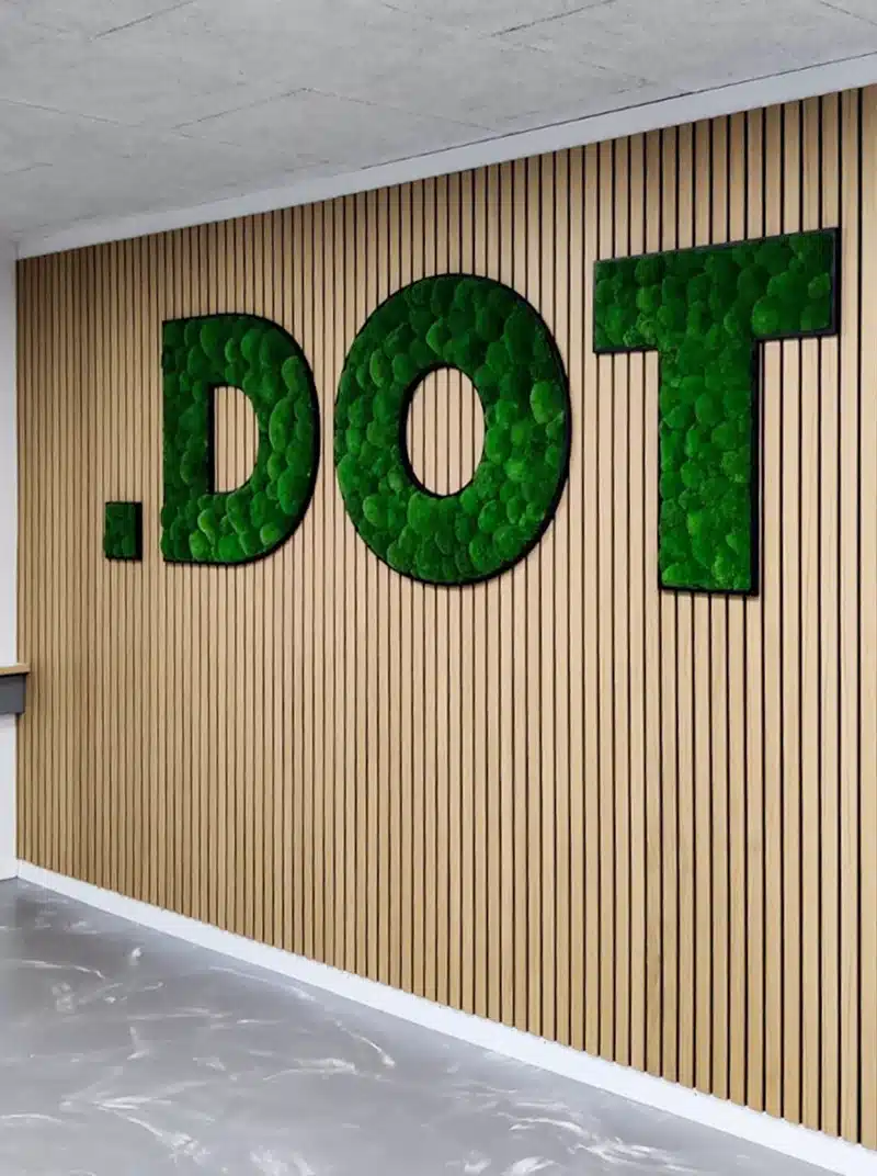 Green dot sign on wooden slat wall.