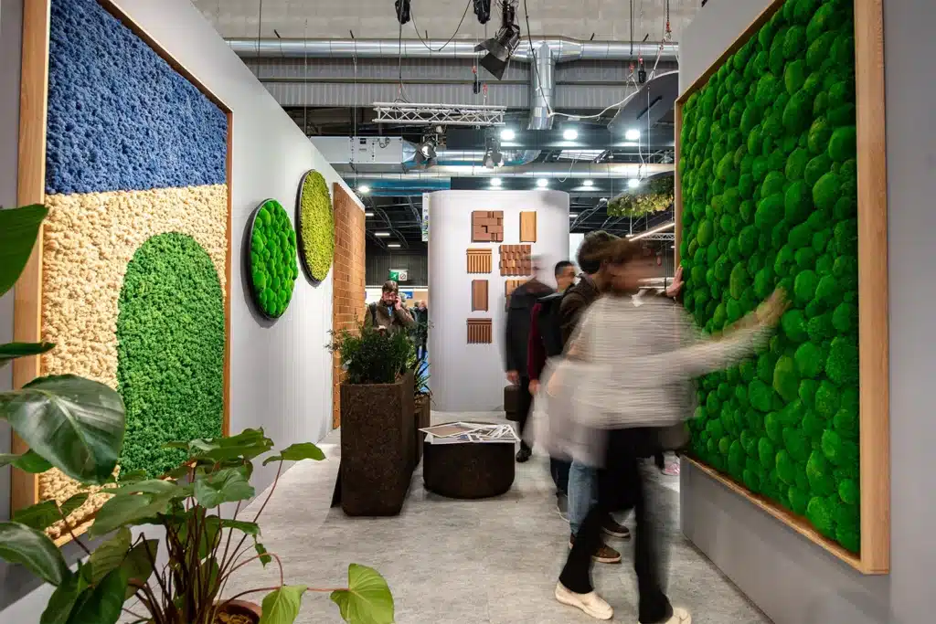 People viewing modern green art installations in gallery.