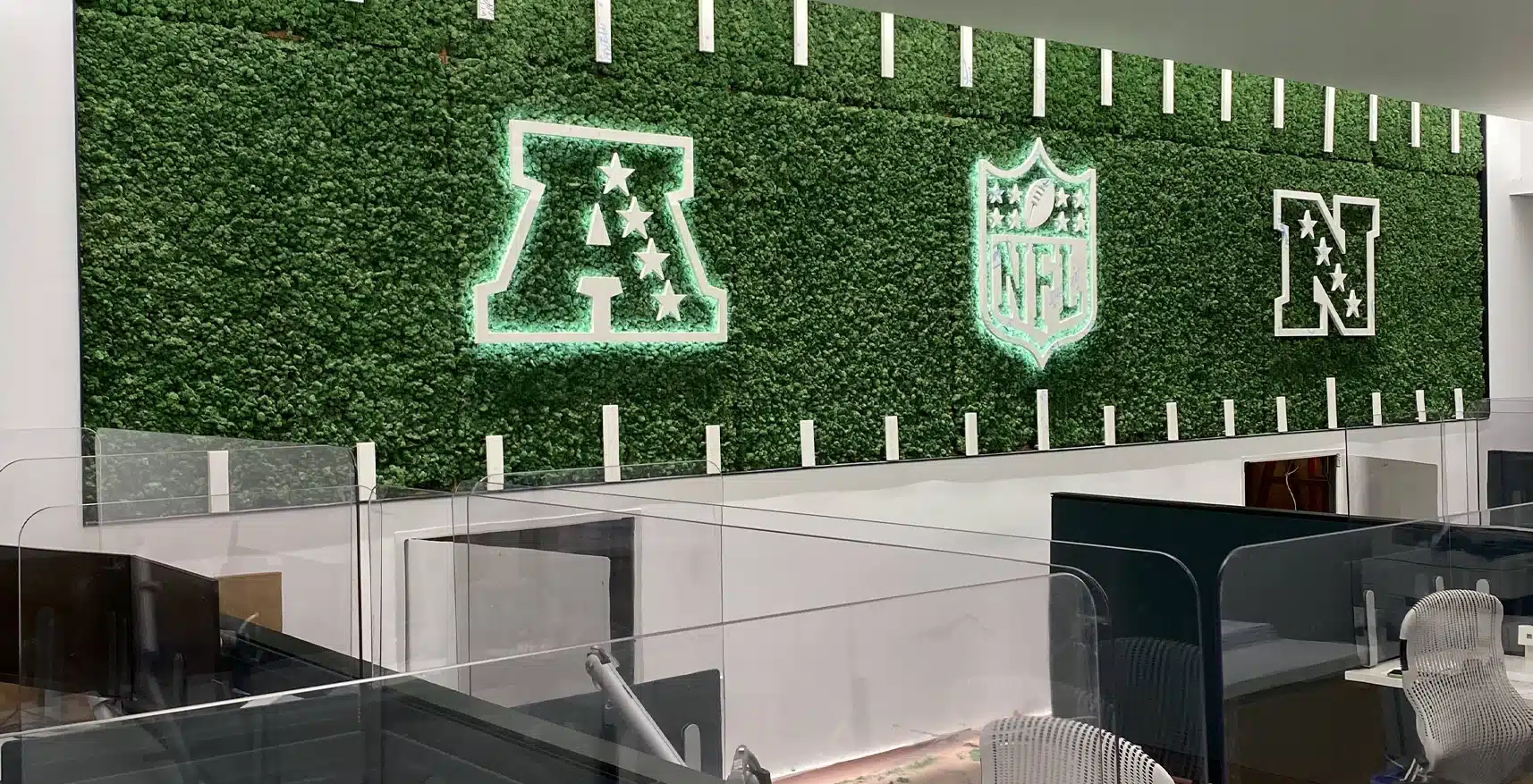 Greenmood stabilized moss feature wall with illuminated logos in a workplace